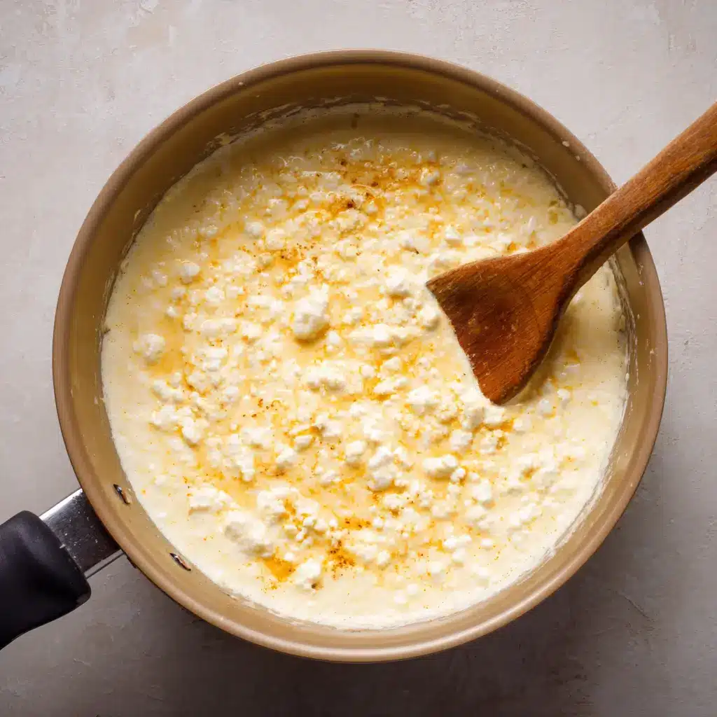 Cottage cheese buffalo dip cooking in a saucepan with wooden spoon