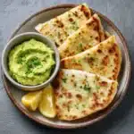 Sliced keto cottage cheese flatbread served with avocado dip and lemon