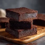 Low-carb cottage cheese brownies stacked on a wooden board